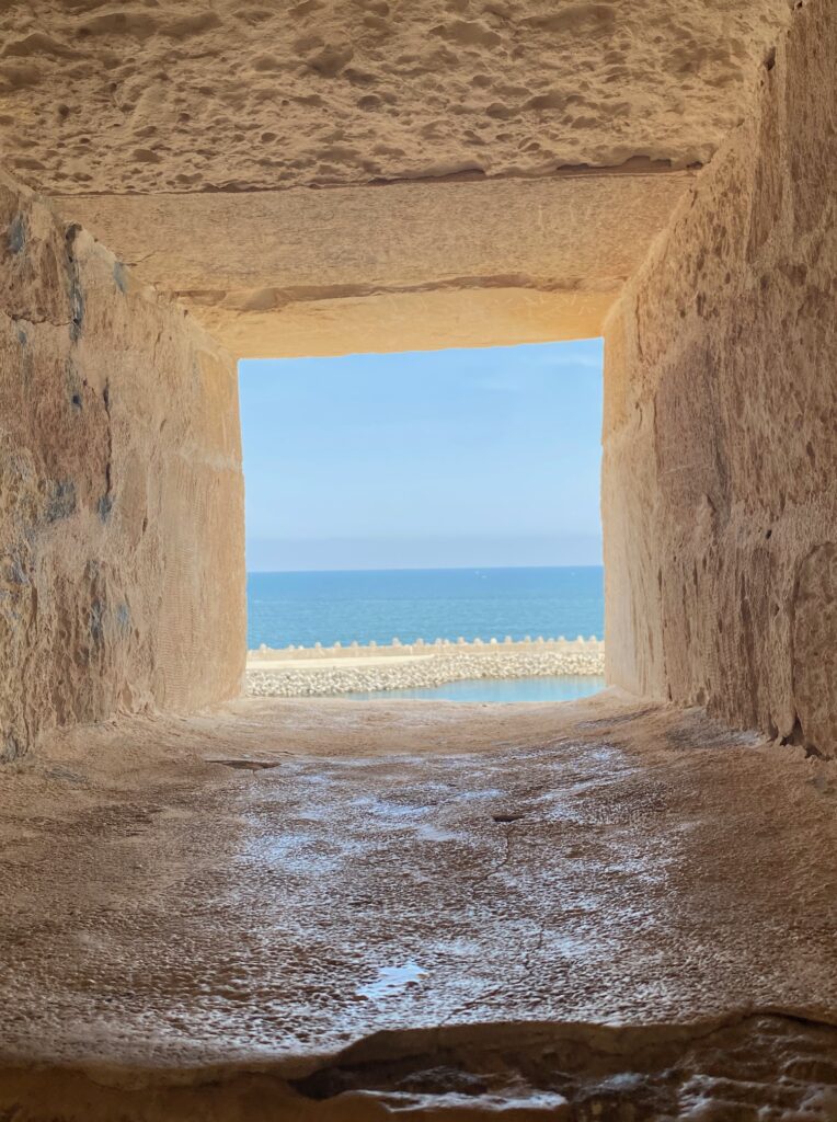 within the old castle there are 'windows' which are just small square cutouts in the stone. this picture is looking out one at the water