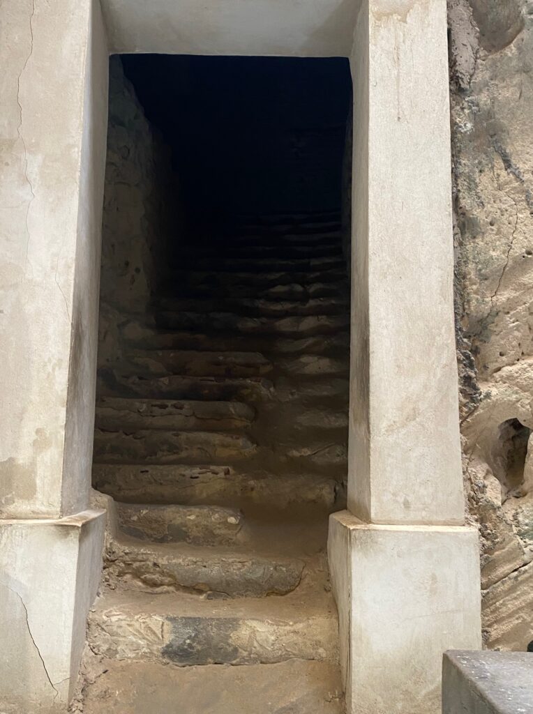 a very spooky stairwell. it is old stone steps that are degraded and it is very dark