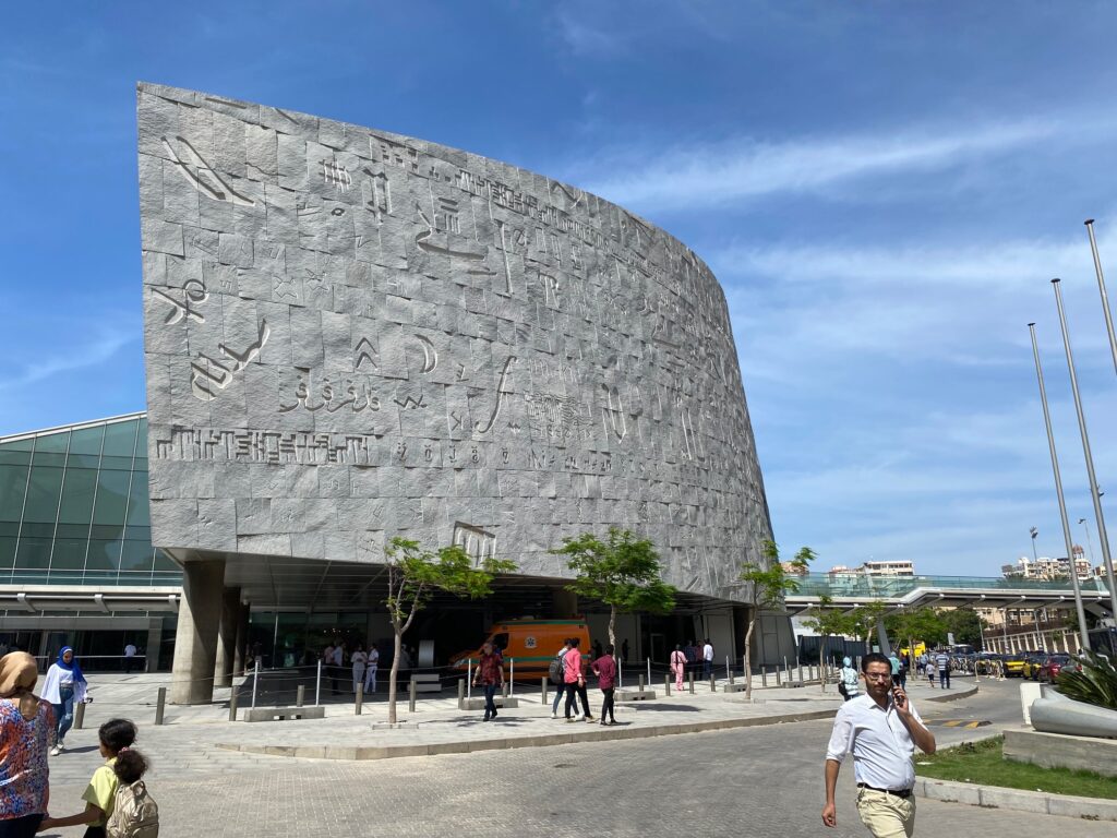 outside of the new library. it is a round stone building with some hieroglyphs carved in it