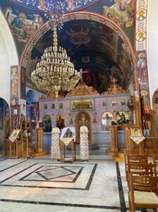 inside of the church with a chandelier and art