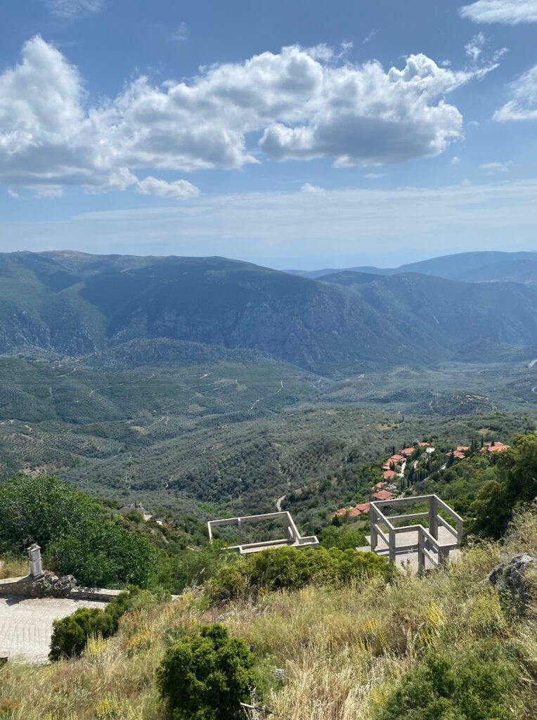 View from up high looking out over the grassy/tree-filled mountains and valley below