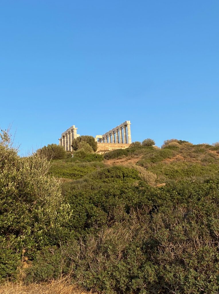 view of poseidon's temple from the bottom (the temple is old stone columns almost in a rectangle shape though not all is there)