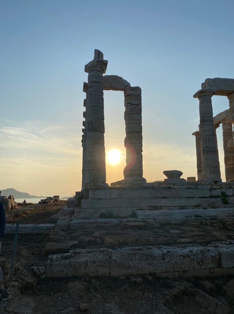 sunset photo of the sun showing between two columns of the temple